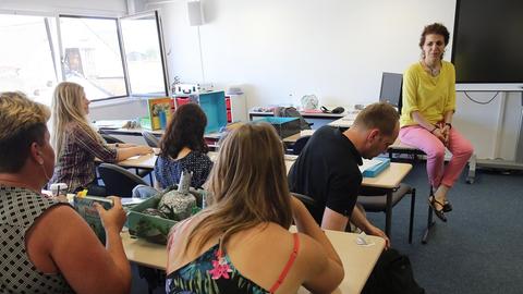 Männer und Frauen in einem Seminarraum in Berlin. Studiert haben sie alle nicht auf Lehramt, sondern etwas anderes. Über einen Quereinstieg gelangten sie in den Schuldienst und qualifizieren sich nun parallel weiter.