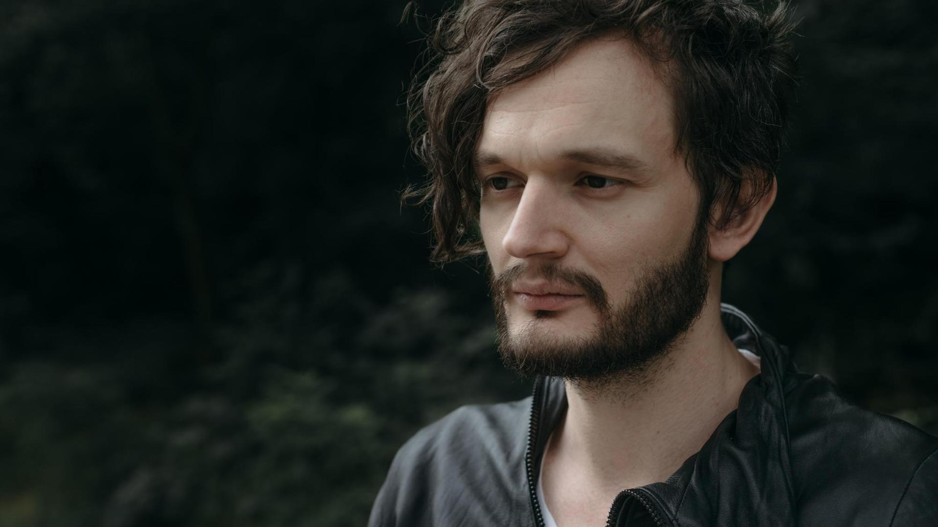 Der Musiker Sascha Ring, aka Apparat, trägt Bart und schaut leicht abwesend zur Seite.