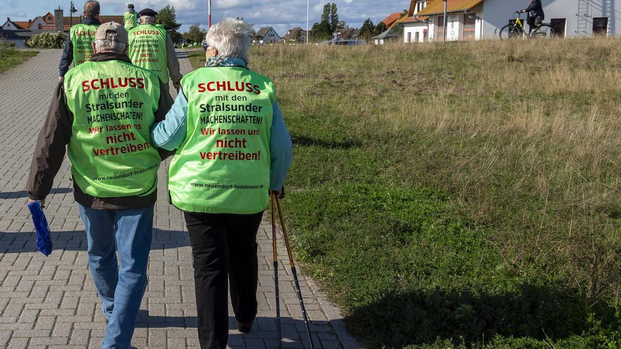 Zwei Hiddenseer mit knallgelben Warnwesten demonstrieren in Neuendorf.