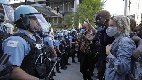 Mehrere Teilnehmer einer Demonstration stehen in Chicago einer Gruppe von Polizisten gegenüber