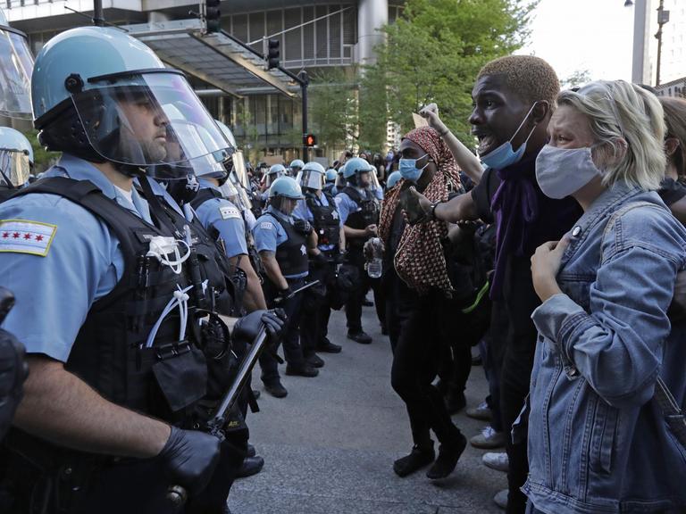 Mehrere Teilnehmer einer Demonstration stehen in Chicago einer Gruppe von Polizisten gegenüber