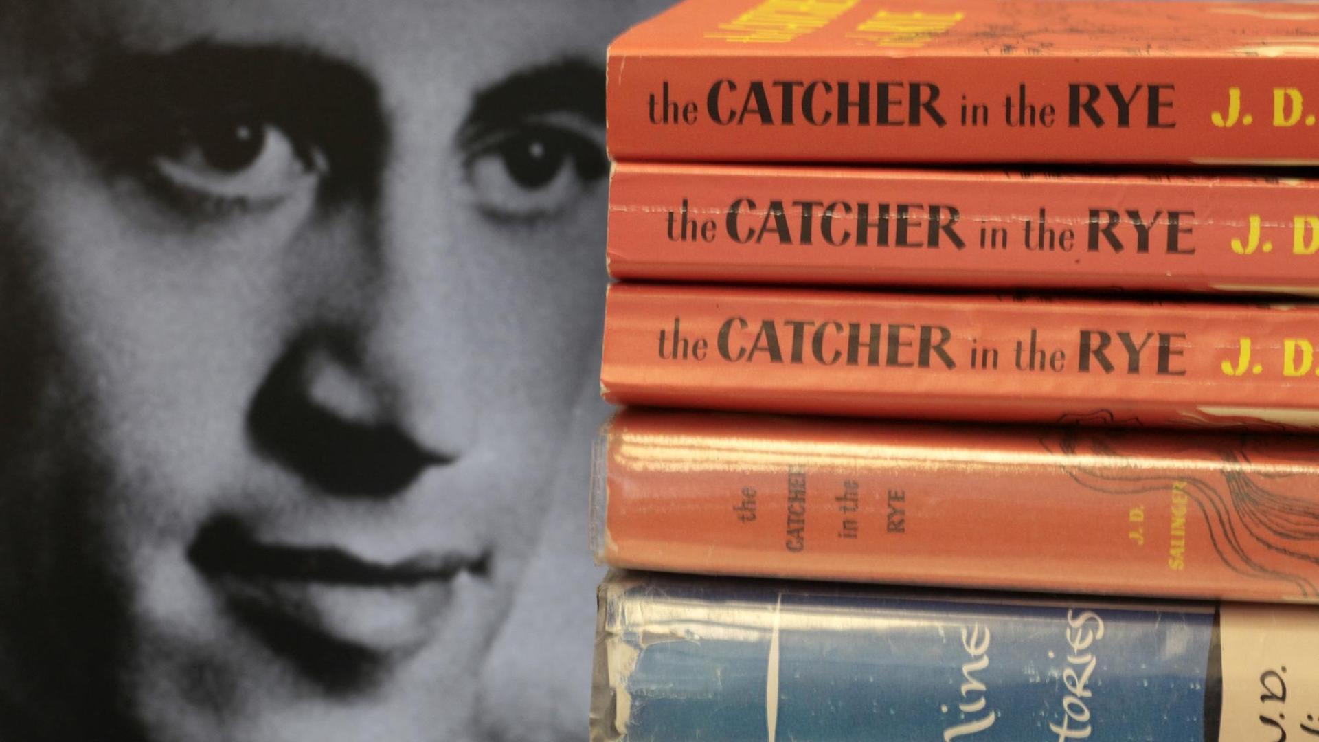 Das Gesicht des Schriftstellers J.D.Salinger ist neben aufgestapelten Büchern seines Klassikers "Der Fänger im Roggen" zu sehen