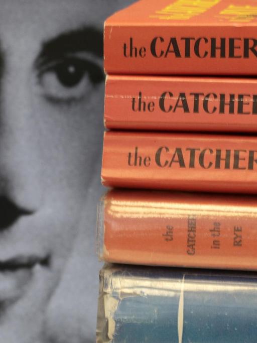 Das Gesicht des Schriftstellers J.D.Salinger ist neben aufgestapelten Büchern seines Klassikers "Der Fänger im Roggen" zu sehen