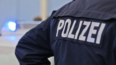 Polizei-Schriftzug auf dem Rücken eines Polizisten