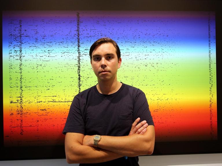 Der Künstler James Bridle vor einem seiner Bilder zur Ausstellung "The Glomar Response" in Berlin - mit Kunst zur Überwachung.