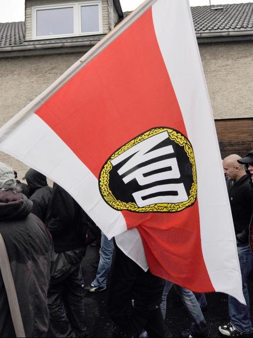 Begleitet von Polizisten ziehen am 07.11.2009 Anhänger der rechtsextremen NPD im hessischen Friedberg durch ein Wohngebiet.