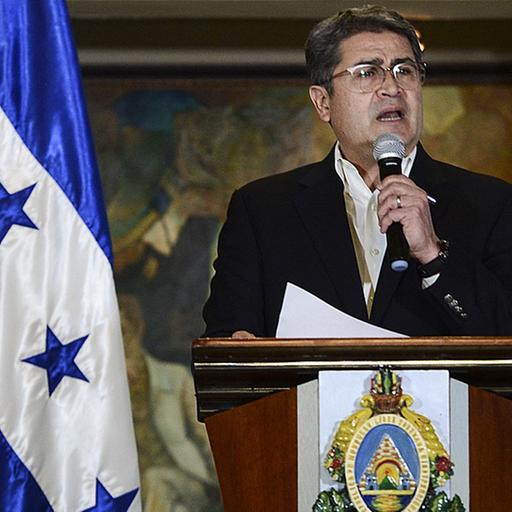 Porträt von Juan Orlando Hernández am Rednerpult.