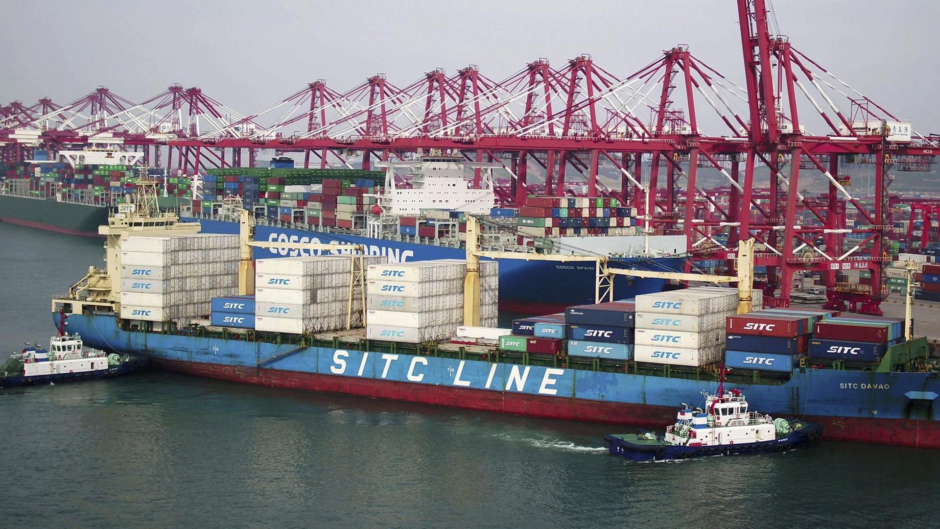 Zwei Lastkähne bringen ein Containerschiff zur Werft in Qingdao in der ostchinesischen Provinz Shandong.