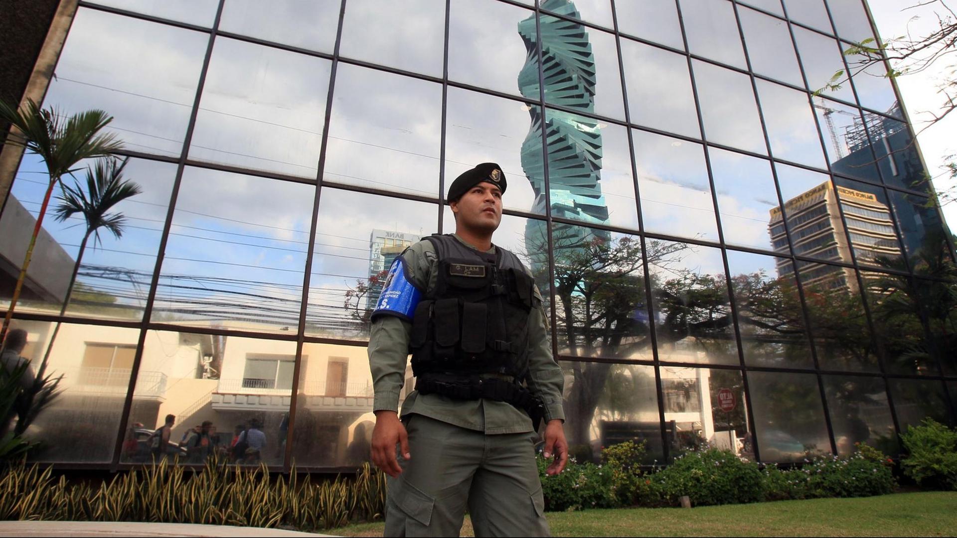 Ein Polizist steht vor einem Glasgebäude, der Zentrale der Kanzlei Mossack Fonseca in Panama City.