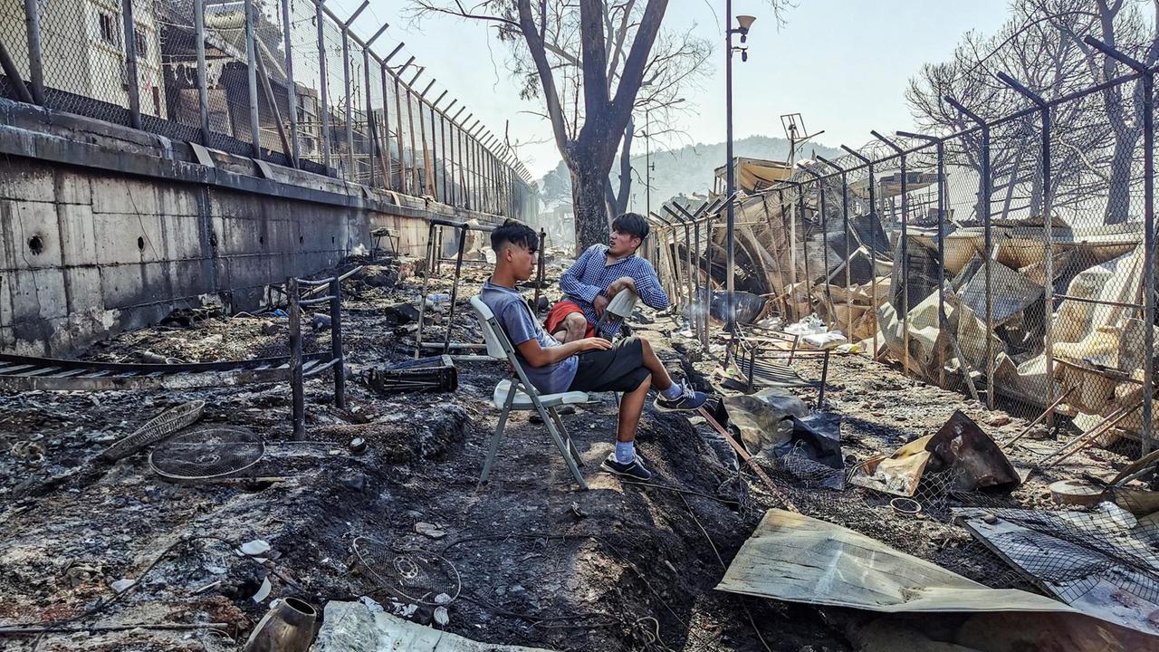 Das Foto zeigt Migranten im abgebrannten Lager von Moria.