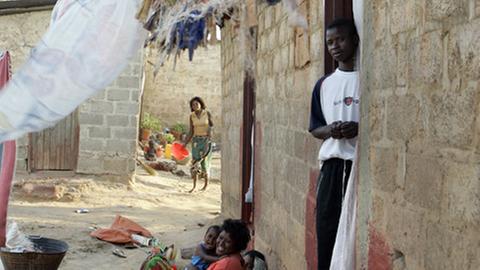 Bewohner vor ihren schmucklosen Wohnhäusern aus Stein in einem Armenviertel in Lusaka, der Hauptstadt des südafrikanischen Staates Sambia.