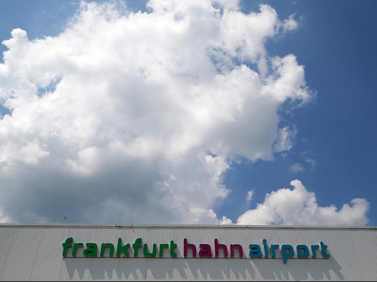 Die Aufschrift "frankfurt hahn airport" prangt auf einem Gebäude, darüber blauer bewölkter Himmel