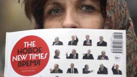 Russian opposition journalists, Zoya Svetova holds a copy of weekly The New Times outside a court in Moscow, on December 13, 2013. Svetova and The New Times were sentenced today to just over one million rubles fine ( about 25,000 euros) for "defamation" against two judges.