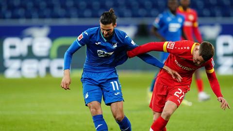 Fußball: Bundesliga, TSG 1899 Hoffenheim - Bayer Leverkusen, 28. Spieltag in der PreZero Arena. Hoffenheims Florian Grillitsch und Leverkusens Florian Wirtz (r) in Aktion.