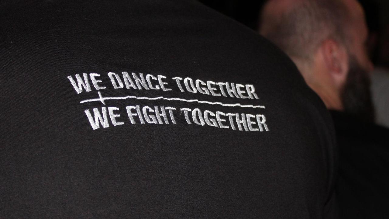 Ein Türsteher vor dem Nachtclub Bassiani trägt ein T-Shirt mit dem Motto "We Dance Together We Fight Together?. 