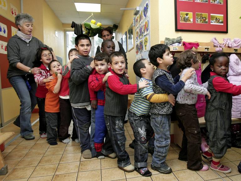 Kinder in einer Kindertagesstätte laufen in einer einer Schlange.