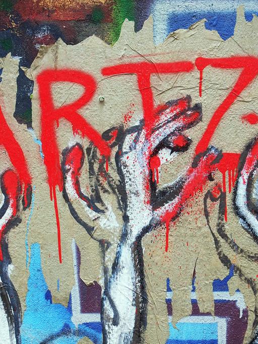 Ein unbekannter Street-Art-Künstler hat auf einer Mauer an einem besetzten Haus in Berlin im Bezirk Mitte dieses Bild geschaffen, das seine Meinung zu den Hartz IV Gesetzen drastisch wiedergibt, aufgenommen am 17.05.2014.