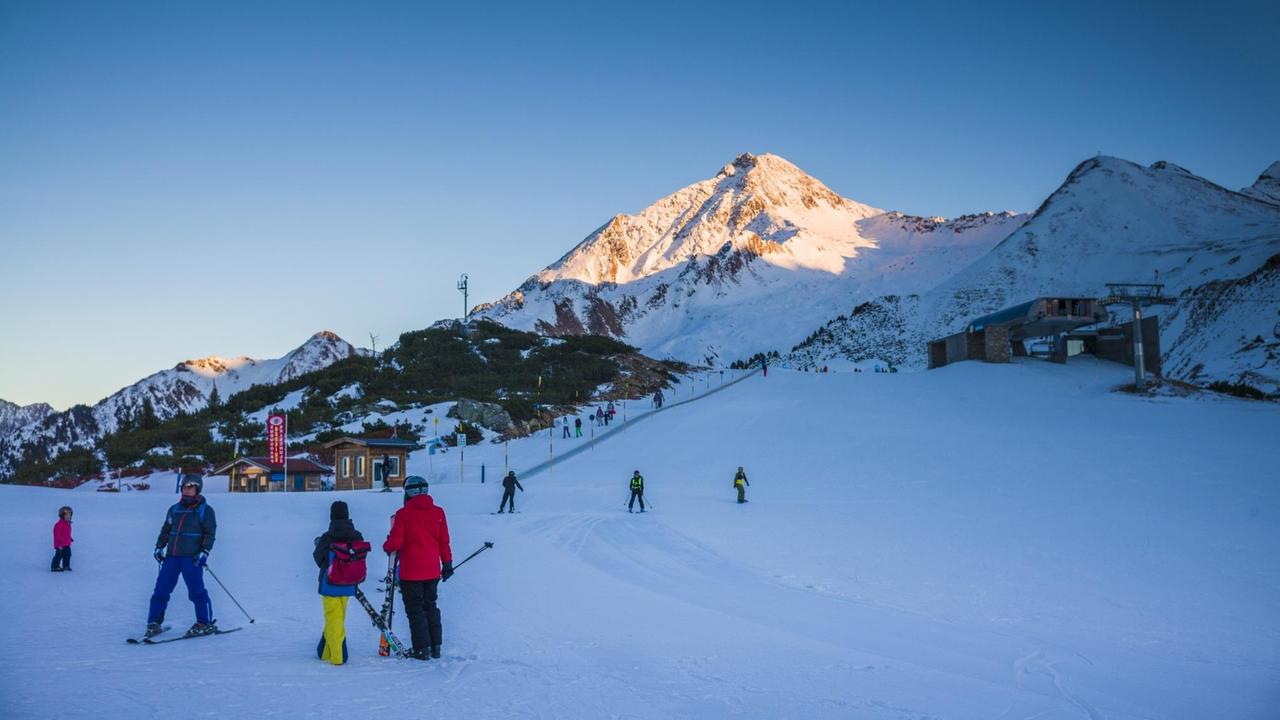 Vereinzelte Skifahrer in den Zillertaler Alpen in der Dämmerung.