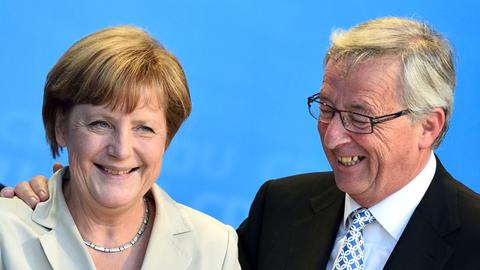 Der christdemokratische Spitzenkandidat für die Europawahl, Jean-Claude Juncker und Bundeskanzlerin Angela Merkel umarmen sich am 23.05.2014 in Saarlouis bei einer CDU-Wahlkampfveranstaltung.