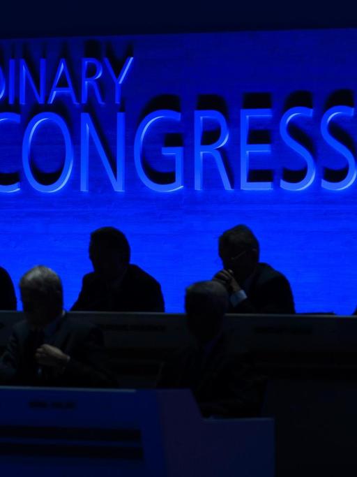 Schwarze Silhouetten vor einer blauen Wand, auf der "Extraordinary FIFA Congress 2016" steht.