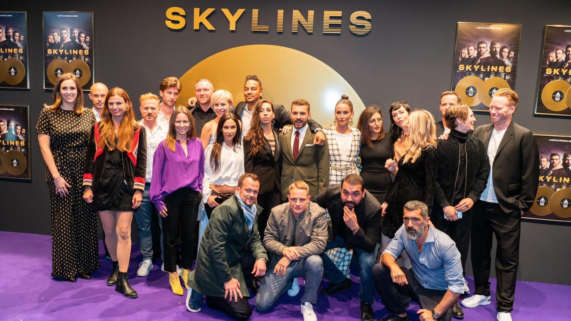 Ein großer Teil der Mitwirkenden, dazu Regie und Produzenten-Team, stehen auf dem Roten Teppich zur Premiere der neuen deutschen Netflix-Serie "Skylines" für ein Gruppenbild zusammen.
