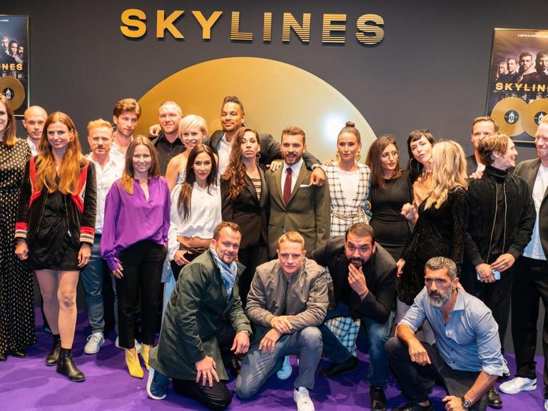 Ein großer Teil der Mitwirkenden, dazu Regie und Produzenten-Team, stehen auf dem Roten Teppich zur Premiere der neuen deutschen Netflix-Serie "Skylines" für ein Gruppenbild zusammen.
