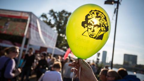 Das Konterfei von Ludwig van Beethoven auf einem Luftballon wird gegen die Sonne gehalten.