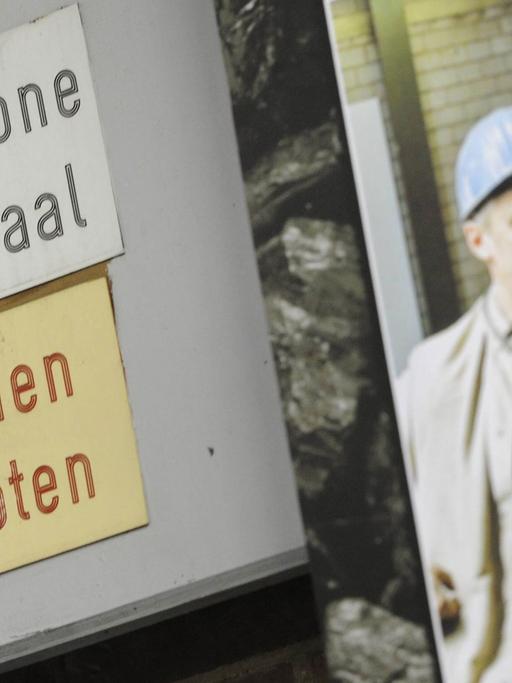 Im Bergwerk Saar der "RAG Deutsche Steinkohle" in Ensdorf im Saarland hängt neben zwei Schildern ein Foto mit ehemaligen Arbeitern