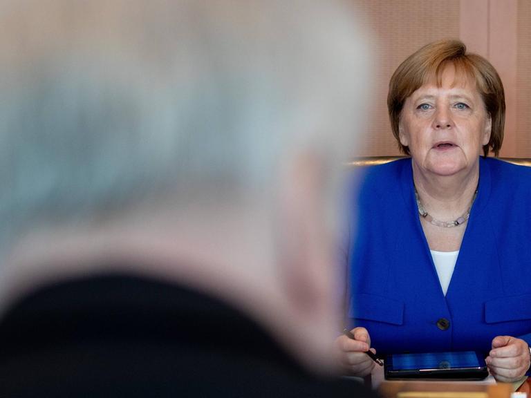 Berlin: Bundeskanzlerin Angela Merkel (CDU) blickt zu Beginn der Sitzung des Bundeskabinetts zu Horst Seehofer (CSU), Bundesminister des Innern, für Bau und Heimat.
