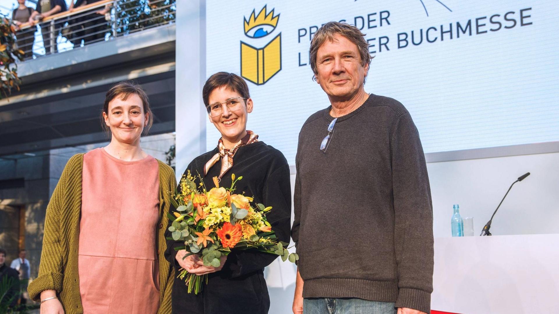 Eva Ruth Wemme, Anke Stelling und Harald Jähner stehen auf einer Bühne.