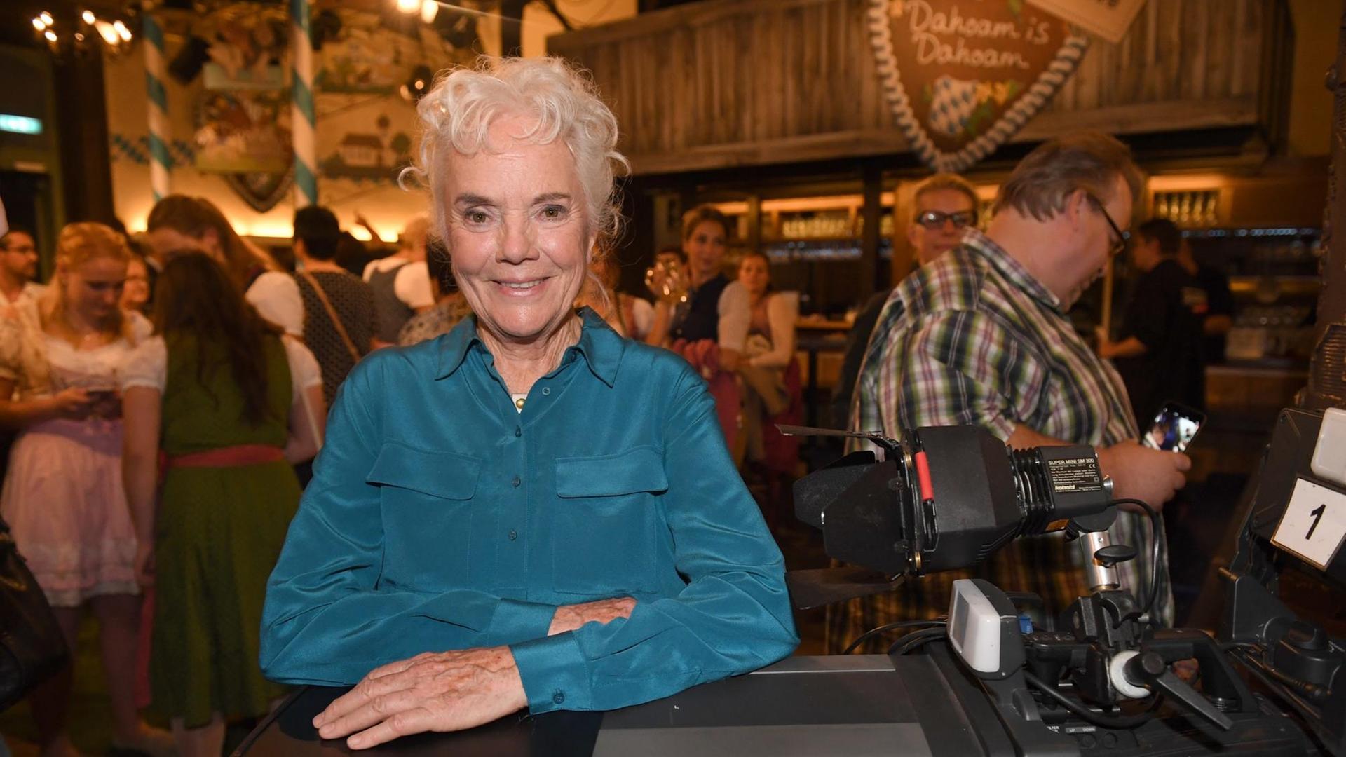 Die Schauspielerin Ursula Erber auf eine Fernsehkamera gelehnt