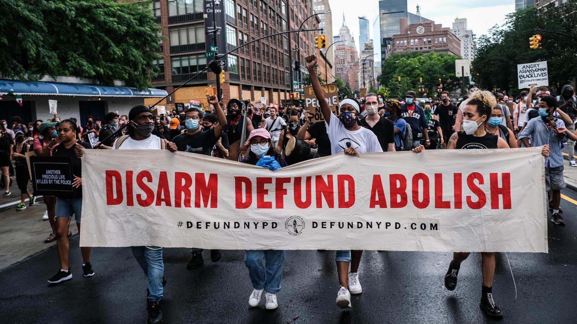 Demonstranten in New York City tragen ein Transparent mit der Aufschrift: "Disarm Defund Abolish".