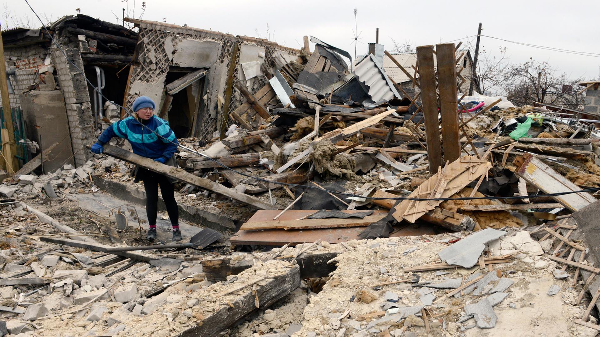 Eine Frau in Donezk in den Trümmern ihres Hauses, das bei Kämpfen zerstört wurde.