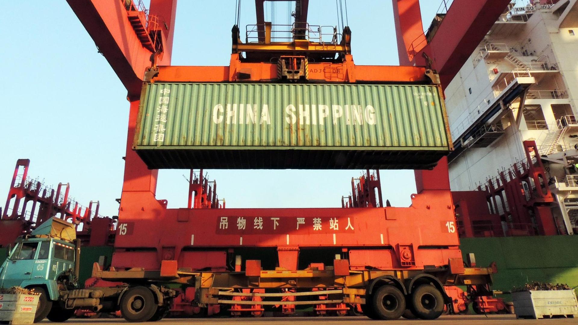 In einem Hafen im Osten Chinas werden Container verladen.