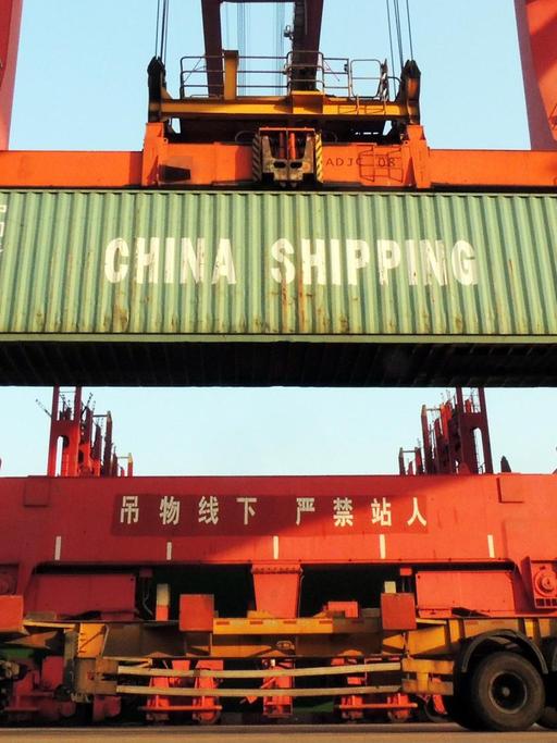 In einem Hafen im Osten Chinas werden Container verladen.