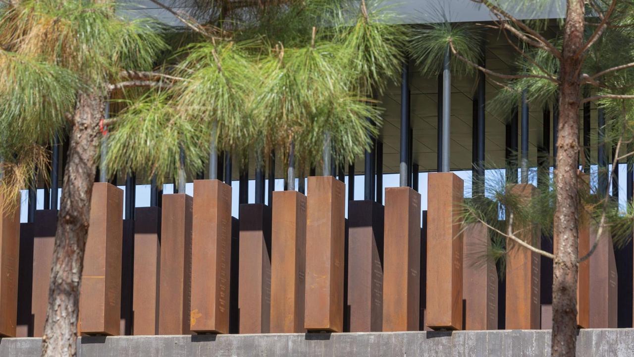 Blick auf das "National Memorial for Peace and Justice" in Montgomery, Alabama, mit Stahlkörpern und Bäumen davor