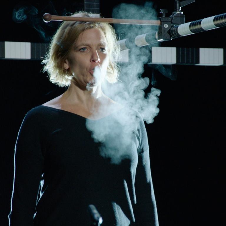 Eine Sängerin singt in einem Versuchsaufbau, bei dem Reichweiten der Aerosole gemessen werden.
Eine Sängerin singt in einem Versuchsaufbau, bei dem Reichweiten der Aerosole gemessen werden.