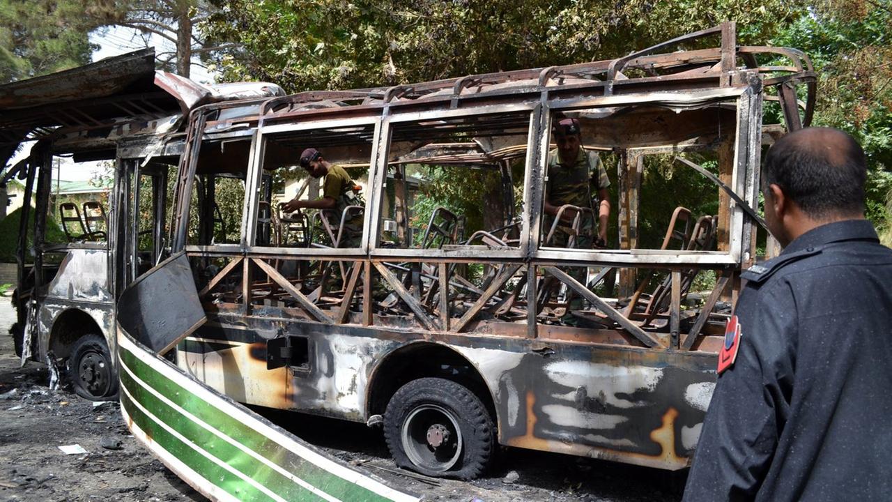 (130616) -- QUETTA, June 16, 2013 () -- Pakistani security personnel inspect the burnt student bus a day after it was destroyed by a bomb blast in southwest Pakistan's Quetta, June 16, 2013. A day of mourning was observed across Pakistan's southwestern Ba