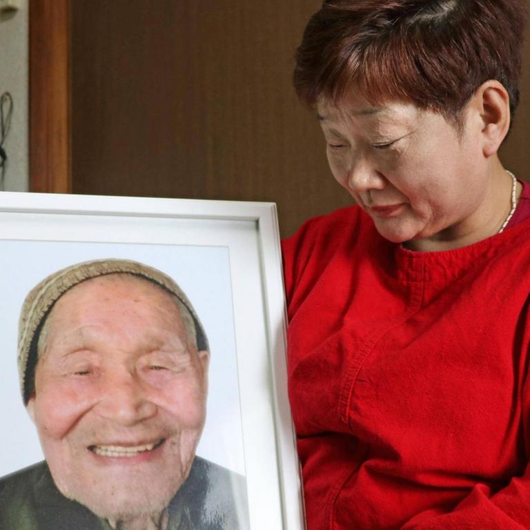 Mieko Okubo hält ein Foto ihres Schwiegervaters Fumio Okubo in die Kamera - der 102jährige hatte im April 2011 angesichts einer Evakuierungs-Anordnung Suizid verübt.