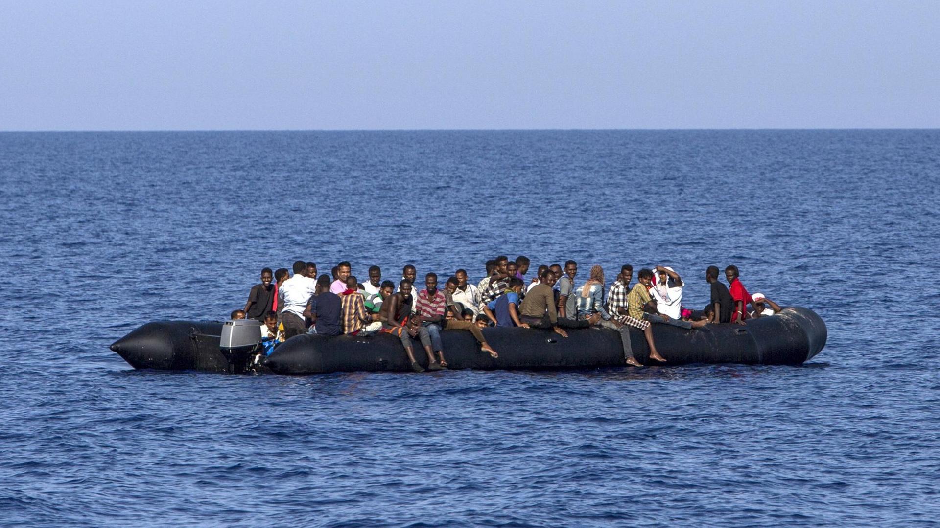 Migranten aus Afrika warten 30 Kilometer vor der libyschen Küste in einem Schlauchboot auf ihre Rettung