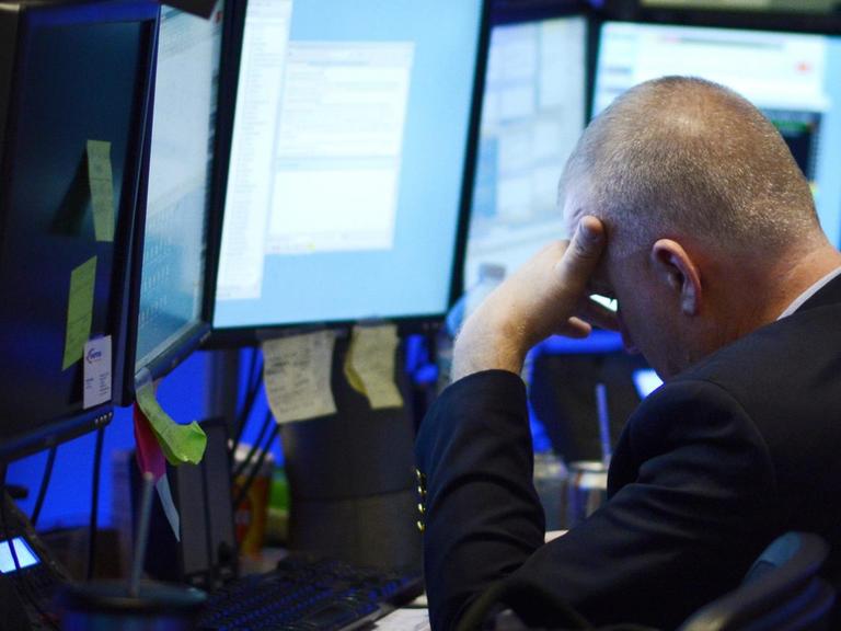 Ein Börsenmakler an der Wall Street in New York legt das Gesicht angesichts hoher Kursverluste in die Hände.
