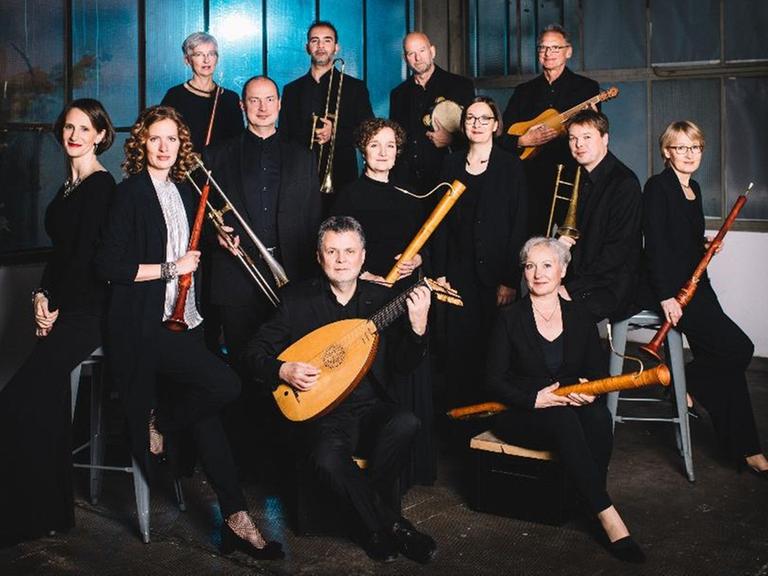 Die Mitglieder stehen beieinander mit ihren Instrumenten. Die Mitglieder stehen beieinander mit ihren Instrumenten.