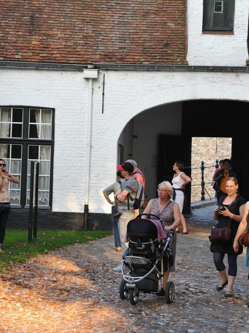 Touristengruppe im Beginenhof (flämisch: Begijnenhof) im belgischen Brügge