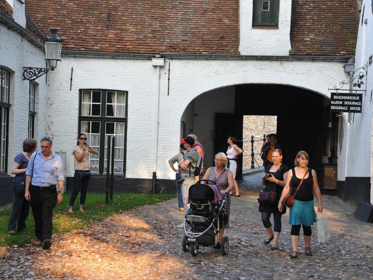 Touristengruppe im Beginenhof (flämisch: Begijnenhof) im belgischen Brügge