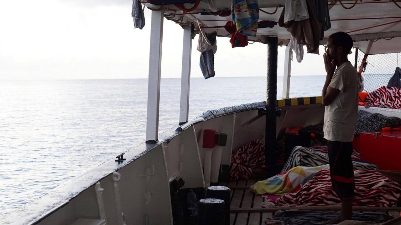 Ein Migrant steht an Deck des spanischen Seenotrettungsschiffes "Open Arms"
