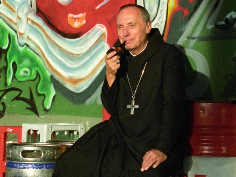 Porträt des Benediktinermönchs Notker Wolf beim Pfeife Rauchen.