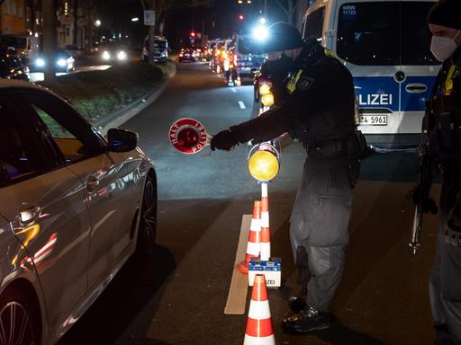 Polizisten kontrollieren an einer Ausfallstraße in Dortmund Fahrzeuge.