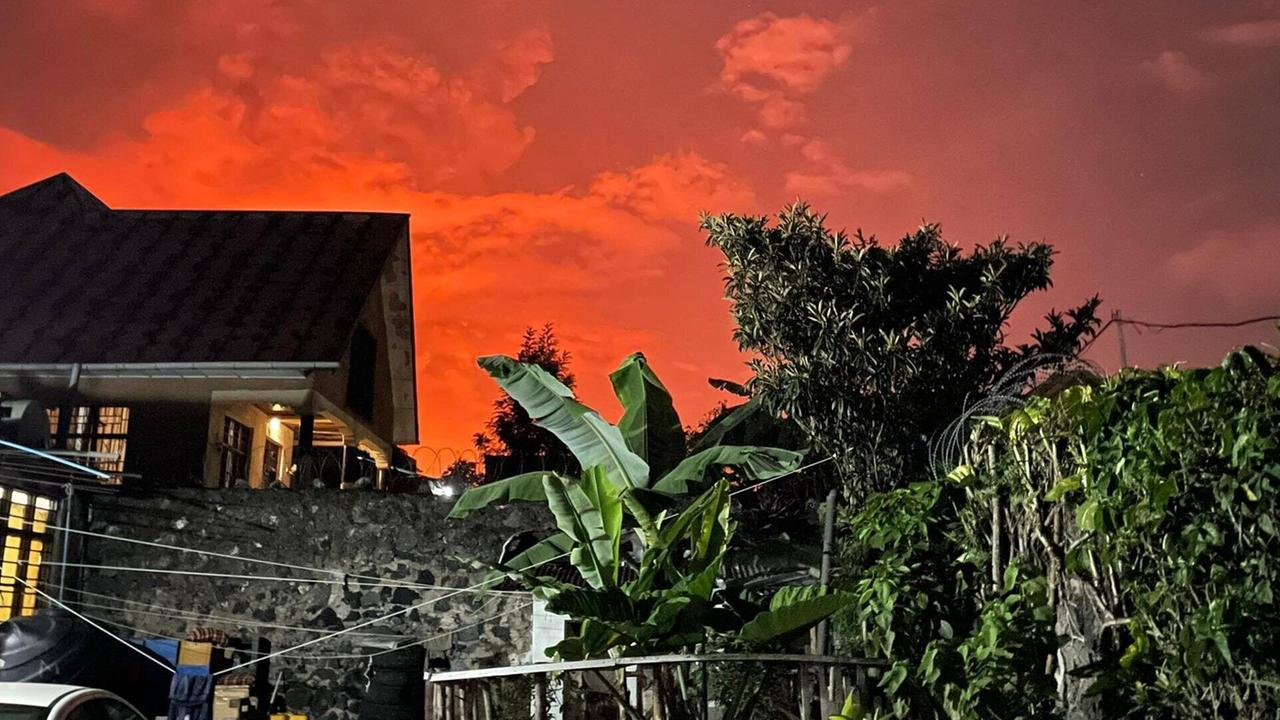 Nachtansicht eines Hauses vor dem Hintergrund eines glühend roten Himmels.