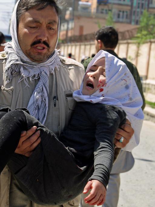 Ein Mann trägt am 22.4.2018 in der afghanischen Hauptstadt Kabul ein bei einem Selbstmordanschlag verwundetes Kind.