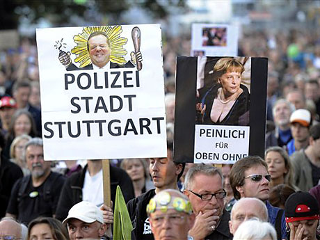 Ein Gegner des Bahnhofprojekts "Stuttgart 21" hält im Schlosspark in Stuttgart ein Schild, auf dem "Polizei Stadt Stuttgart" steht.